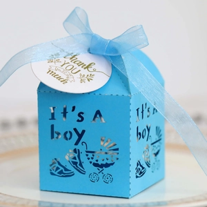 Detail of blue laser-cut baby shower candy box with It's A Boy text and a thank you tag