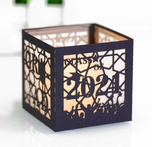 Macro view of Class of 2024 laser cut black paper lantern with candle light silhouettes
