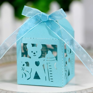Detail of laser-cut blue baby bear gift box with a silk ribbon bow and heart pattern