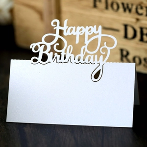 Close-up of white pearlescent hollow laser-cut Happy Birthday standing place card