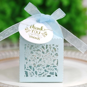 Detail of laser-cut rose hollow favor box with thank you tag and sheer ribbon