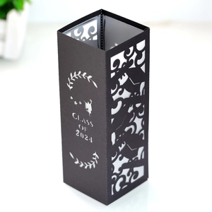 Macro view of Class of 2024 laser-cut black paper candle shade with graduation cap motifs
