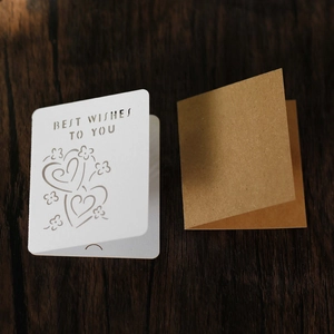 Detail of laser-cut floral heart patterns and Best Wishes text on creative kraft cards