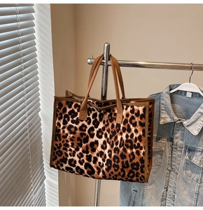 Detail of leopard print tote bag featuring sturdy canvas material and brown textile straps