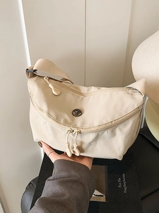 Beige nylon crossbody dumpling bag with wide shoulder strap and circular logo detail
