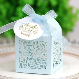 Close-up of laser-cut flower patterns on light blue gift box with thank you tag