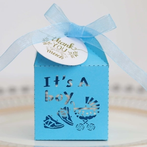 Close-up of blue laser-cut Boy baby shower candy box with stroller design and thank you tag