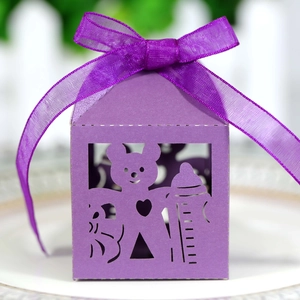 Close-up of laser-cut purple gift box with baby bear and milk bottle pattern and ribbon