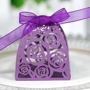Close-up of purple laser-cut rose wedding favor box with a delicate chiffon ribbon bow