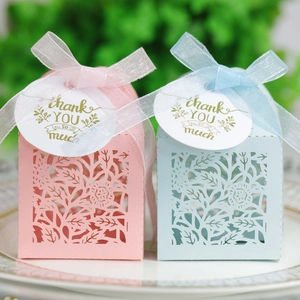 Close-up of laser-cut gift boxes with ribbons and Thank You tags in pink and blue