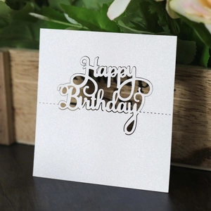 Detailed view of white glitter laser-cut Happy Birthday place card on a wooden surface