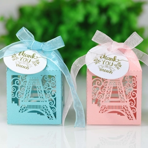 Close-up of laser-cut Eiffel Tower candy boxes with elegant ribbons and thank you tags
