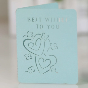 Detail of light blue greeting card with laser-cut heart patterns and Best Wishes text