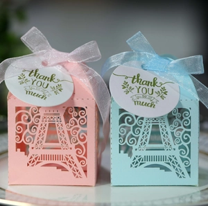 Detail of laser-cut Eiffel Tower favor boxes with ribbons and thank you cards