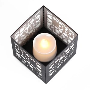 Detail of square black hollow-out paper lantern with warm LED candle light for party decor