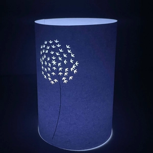 Laser-cut paper lantern with dandelion design emitting soft blue ambient light