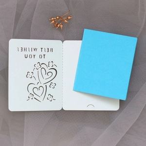 Macro view of white laser-cut card with Best Wishes engraving and blue insert