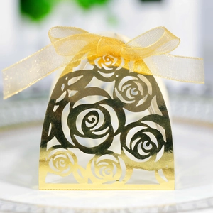 Detailed view of golden laser-cut rose hollow favor box with yellow organza ribbon bow