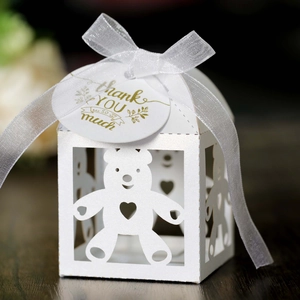 Detail van witte lasergesneden beertjesdoos met lint en gouden bedanklabel