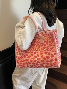 Trendy leopard print tote bag with pink canvas straps shown on model in stylish indoor setting