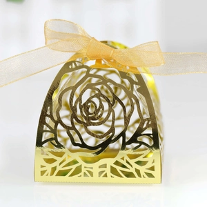 Detailed laser-cut rose pattern on gold candy box with matching organza ribbon bow