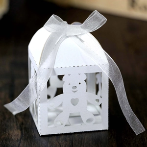 Macro detail of laser-cut teddy bear white candy box with organza ribbon bow decoration