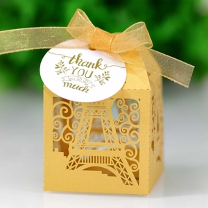 Detailed laser-cut Eiffel Tower favor box with gold ribbon and thank you tag