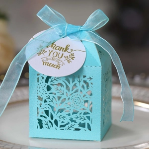 Close-up of laser-cut hollow blue gift box with Thank You tag and sheer ribbon bow