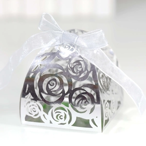 Detail of silver laser-cut rose hollow candy box with a white organza ribbon bow
