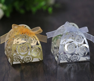 Laser-cut rose pattern candy boxes in gold and silver with elegant organza ribbon bows