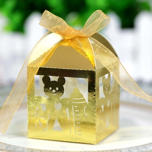 Detail of laser-cut baby bear and bottle patterns on golden mirror gift candy box