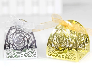 Macro detail of laser-cut rose patterns on gold and silver hollow candy gift boxes