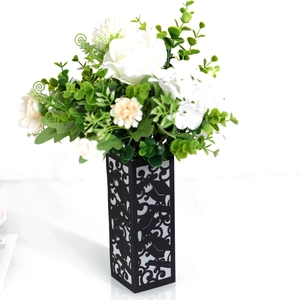 Detail of elegant black hollow-carved vase with white roses and eucalyptus bouquet