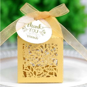 Macro view of gold laser-cut hollow candy box with ribbon and thank you tag