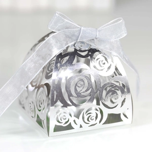 Detail of silver laser-cut rose hollow candy box with elegant ribbon bow for wedding favor
