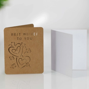 Detail of laser-cut heart pattern on kraft paper greeting card with white insert sheet