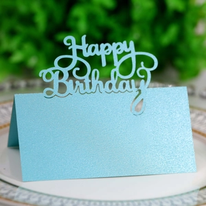 Macro view of light blue glitter place card with laser-cut Happy Birthday lettering