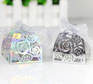 Close-up of laser-cut rose hollow candy box with iridescent finish and white ribbon