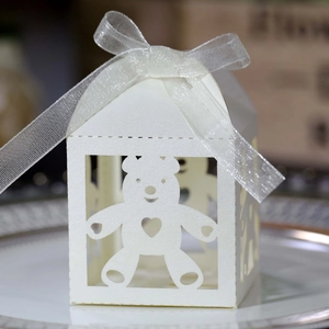 Detail of white laser-cut teddy bear candy box with an elegant translucent ribbon bow