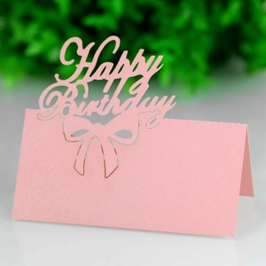 Detail of pink laser-cut Happy Birthday place card with bow design on pearlescent paper