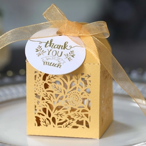 Detailed laser-cut floral gift box with gold ribbon and thank you tag for weddings
