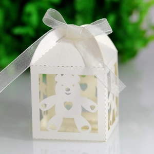 Detail of laser-cut baby bear hollow candy box with white ribbon and heart pattern