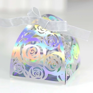 Macro view of laser-cut rose patterns on iridescent cardstock gift box with ribbon