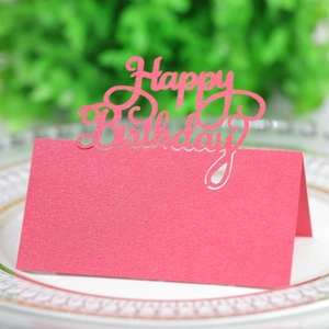 Close-up of laser-cut pink Happy Birthday place card on a white gold-rimmed plate