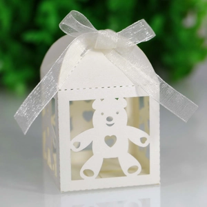 Close-up of white house-shaped gift box with hollow bear and heart cutouts and silk bow
