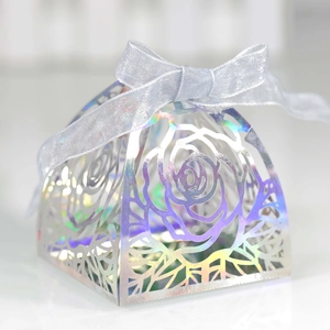 Macro detail of laser-cut rose hollow gift box with holographic silver texture and blue ribbon