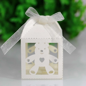 Close-up of white laser-cut hollow bear candy box with white organza ribbon detail