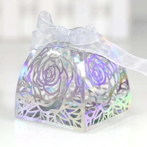 Detailed laser-cut rose patterns on a holographic silver gift box with white ribbon bow