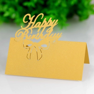 Macro detail of golden Happy Birthday table card featuring hollow laser-cut design