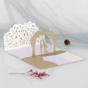 Detailed close-up of 3D laser-cut wedding invitation featuring rose patterns and gold glitter